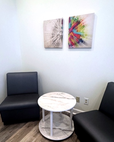 Two grey chairs and a small marble table.